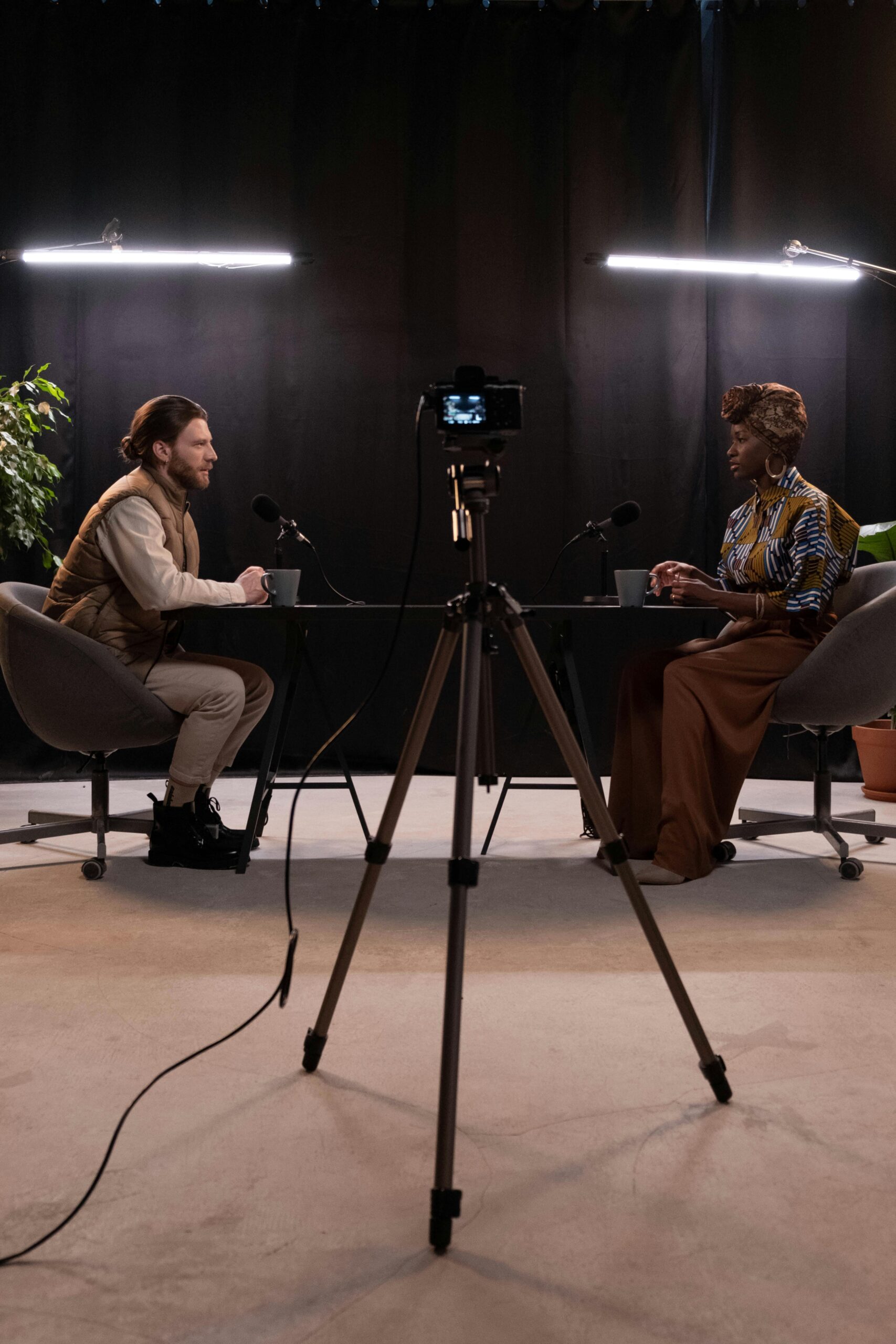 Dynamic podcast session featuring two hosts with studio lighting and recording equipment.